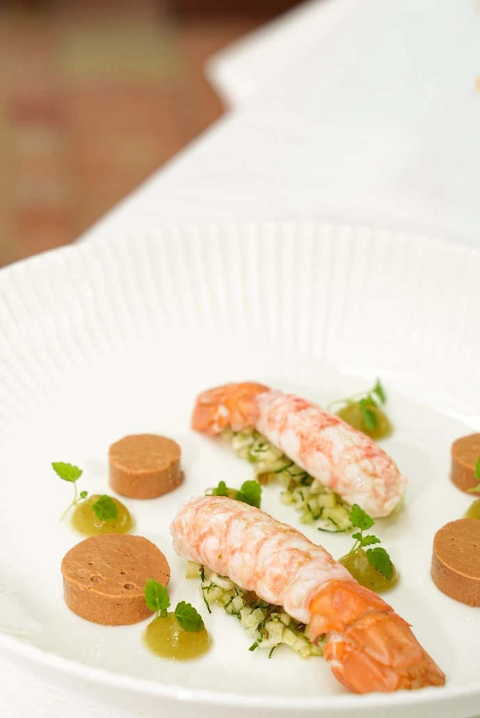 Cette création met à l'honneur la langoustine, produit d'exception apprécié pour sa chair délicate et son goût subtil. Associée à une brunoise de légumes croquants et à des condiments délicatement travaillés, elle révèle un équilibre parfait entre fraîcheur, texture et finesse. Une entrée gastronomique qui illustre le savoir-faire de notre brigade et notre attachement aux produits de qualité.
