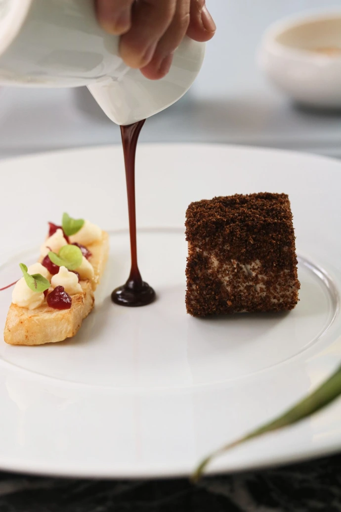Signature originale de notre restaurant gastronomique, ce dessert baptisé Le Cochon joue avec les souvenirs d’enfance et l’esprit de surprise. Entre textures croustillantes, crémeux délicat et sauce chocolat servie à la minute, cette création allie gourmandise, élégance et créativité.  Pensé comme une expérience sensorielle, ce dessert met en scène le savoir-faire du chef à travers un équilibre subtil entre douceur, intensité et raffinement. Chaque élément est travaillé avec précision pour offrir une finale mémorable à votre repas gastronomique.  À la fois ludique et sophistiqué, Le Cochon incarne une pâtisserie contemporaine où la technique se met au service de l’émotion et du plaisir.