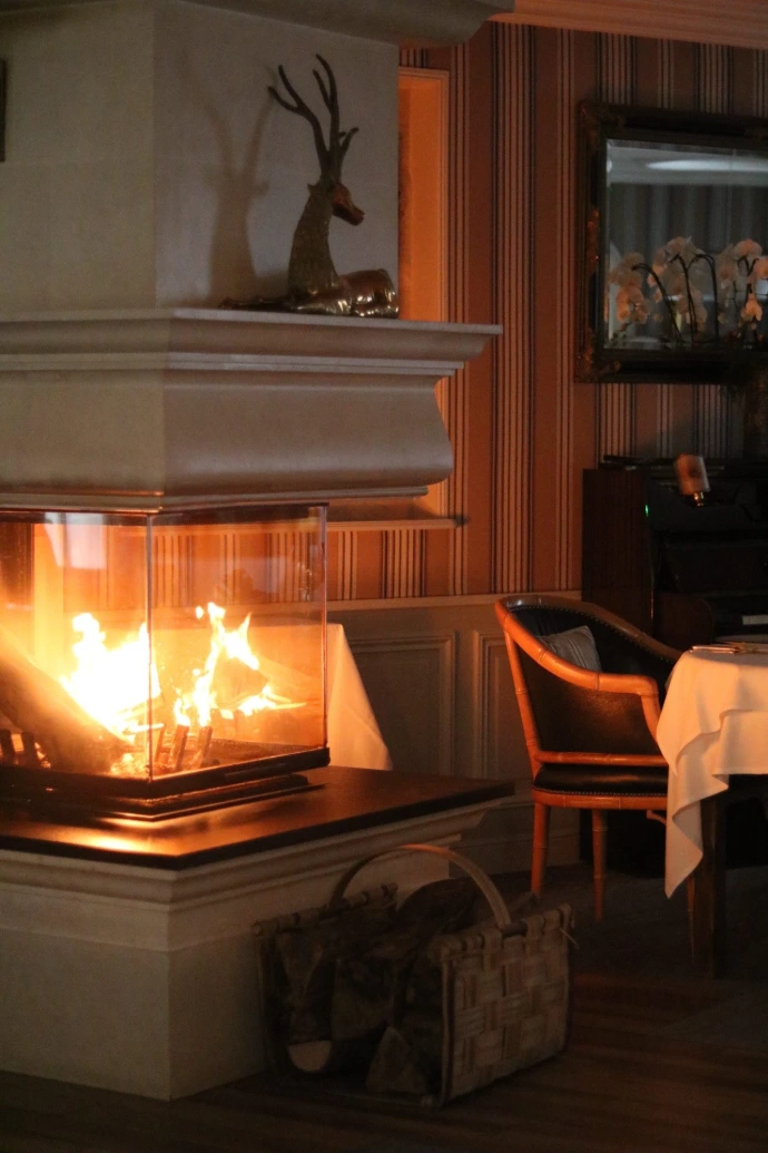 Dès votre arrivée, laissez-vous séduire par l’atmosphère feutrée de notre restaurant gastronomique. Autour de la cheminée crépitante, le temps semble ralentir pour laisser place à un moment de détente, de partage et de gourmandise.  Entre élégance des lieux, service attentionné et cuisine d’exception, chaque détail est pensé pour offrir une expérience unique. La chaleur du feu, le confort de la salle et le raffinement de la table créent un cadre idéal pour un dîner romantique, un repas en famille ou une occasion spéciale.  Dans cet écrin chaleureux, la gastronomie s’apprécie autant par les saveurs que par l’ambiance, faisant de chaque visite un souvenir mémorable.